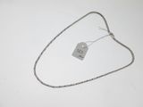 un collier en argent muni d'une plaque, posé sur une surface blanche