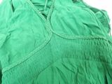 a close up of a green dress with a tie around the neck