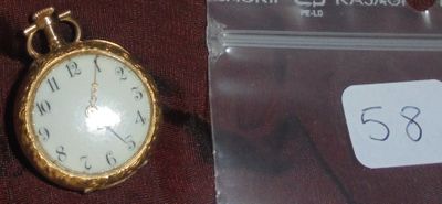 une photo d'une montre de poche à laquelle est attachée une étiquette