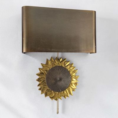 une horloge accrochée au mur, sur laquelle est représenté un tournesol