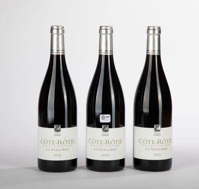 trois bouteilles de vin posées sur une table l'une à côté de l'autre