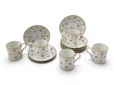 une image représentant un ensemble d'assiettes et de tasses en porcelaine posées sur une surface blanche
