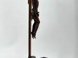 bronze statue of a man on a cross with a bird on a pole