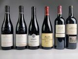 several bottles of wine are lined up in a row on a table