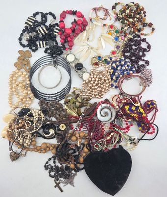a pile of assorted necklaces and bracelets on a white surface