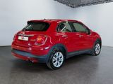 the back of a red car is parked in a large room