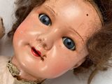 an old doll with a teddy bear on it ' s chest