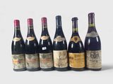 six bouteilles de vin sont alignées sur une surface blanche