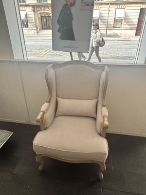 a chair in the corner of a room with a poster on the wall