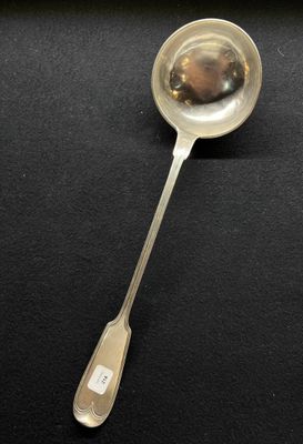 silver spoon on a black surface with a white label on it