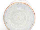 the top of a white and orange vase on a white surface