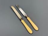 a pair of yellow handled knives on a gray surface