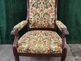 a chair with a floral upholstered back and arms