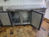 a stainless steel counter with two doors open in a kitchen