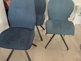 trois chaises bleues placées les unes à côté des autres dans une pièce