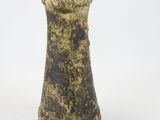 a brown and black vase on a white surface
