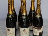 four bottles of champagne are lined up on a marble table