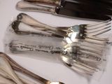 several forks and spoons are lined up on a table