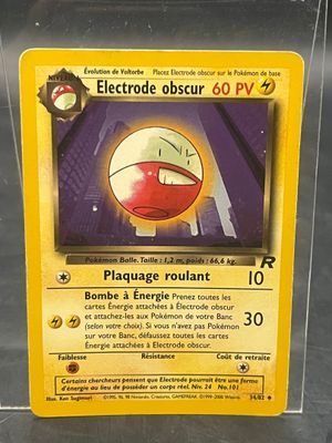 une carte Pokémon dans un étui en plastique posé sur une table