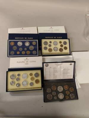 four boxes of coins are sitting on a counter top