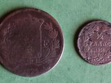 a close up of two coins on a green surface next to each other