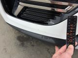 a person holding a ruler in front of a car