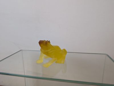 une grenouille jaune assise sur une table en verre