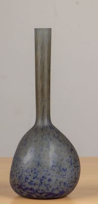 a blue vase sitting on a wooden table with a white wall in the background