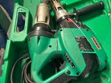 a green box with a drill and other tools in it