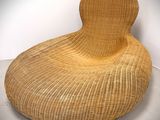 an image of a wicker chair in a room with a white wall