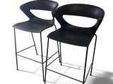 two black chairs sitting next to each other on a white surface