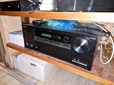 une chaîne hi-fi posée sur une étagère en bois