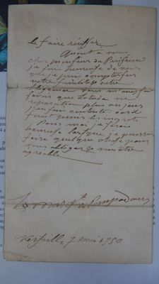 un vieux papier sur lequel est écrite une lettre à la main, posé sur une table