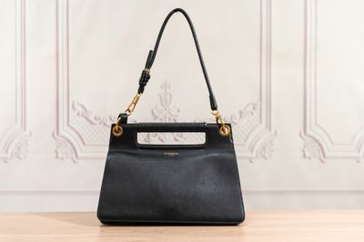 a black handbag sitting on top of a wooden table