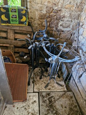 a pile of bikes that are sitting in the corner of a room