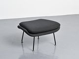an image of a black foot stool in a room with a white wall