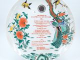 a close up of a plate with birds and flowers on it