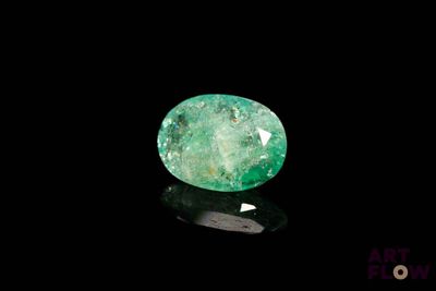 a green emerald stone on a black surface