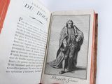 someone is holding an open book with a picture of a man in a robe