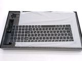 a computer keyboard in a box on a white surface
