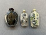 trois flacons à tabac en verre posés sur une surface blanche