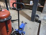 a red fire extinguisor sitting on the floor next to a blue fire hydrant