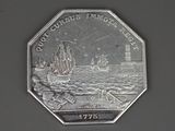 a silver coin with a picture of a ship on it