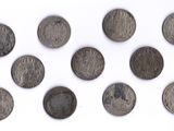 Plusieurs pièces anciennes sont disposées en cercle sur une surface blanche