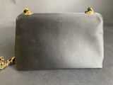 a black and gold clutch bag on a grey background