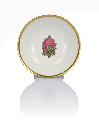 a white bowl with a gold rim and a pink flower on it
