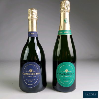 two bottles of champagne sitting next to each other on a table