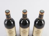 three bottles of wine sitting next to each other on a white surface