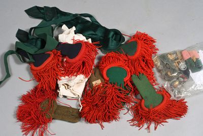 un ours en peluche rouge posé sur une table, à côté d'autres objets