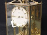 a gold clock that is sitting in a glass case